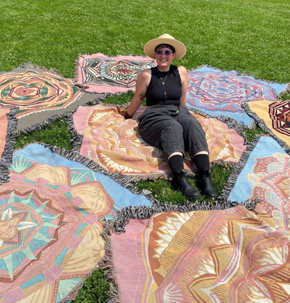 Mackenzie sits among many colorful ritual blankets.