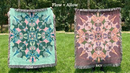 Front and back of a green and blue colorful kaleidoscope patterned woven blanket with the back more a pink and beige