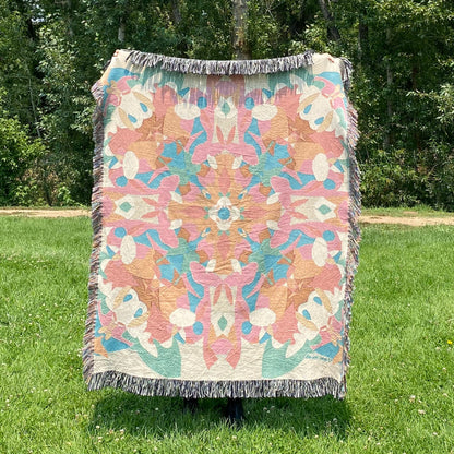 A colorful patterned kaleidoscope patterned blanket with fringe