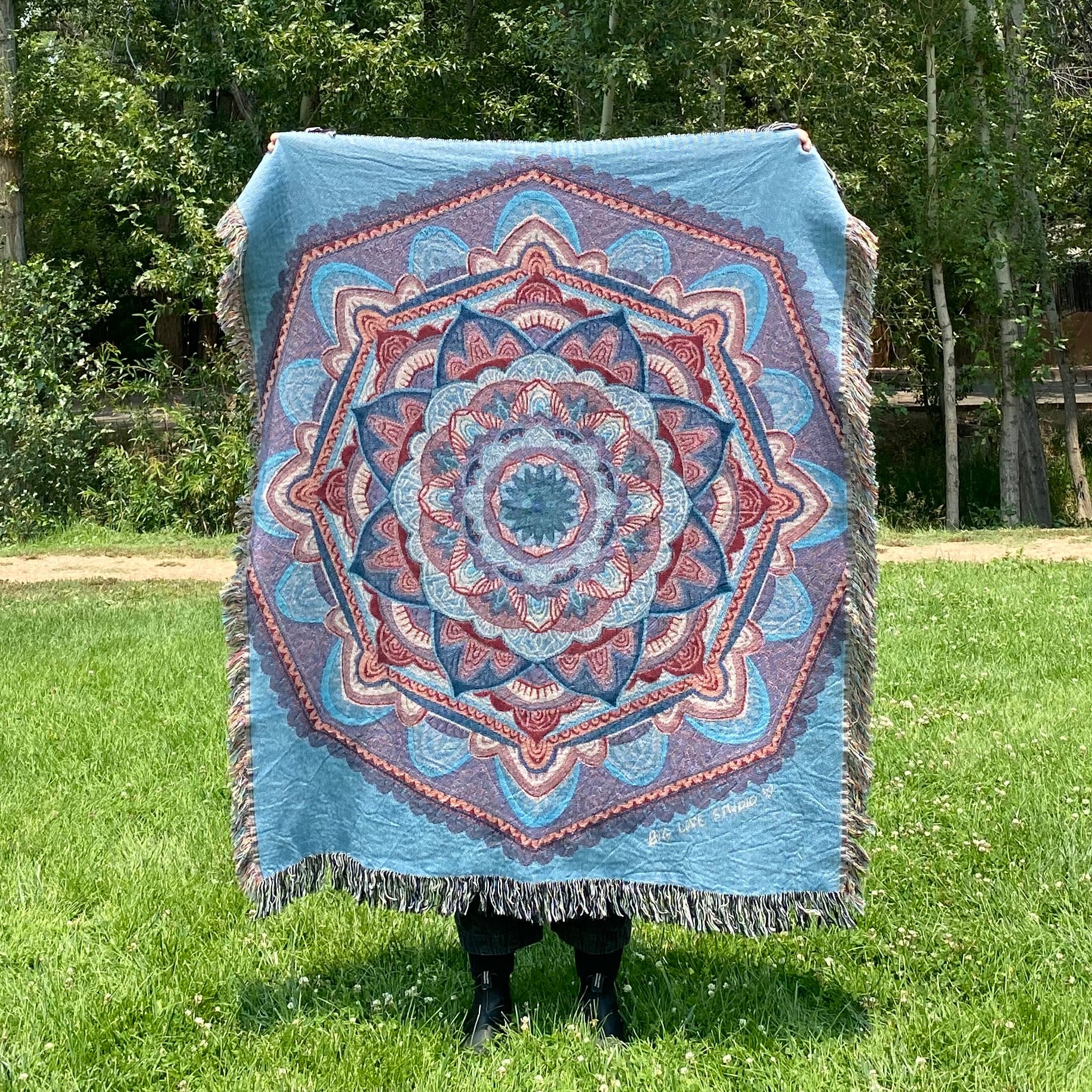 A blue and purple mandala blanket with fringe
