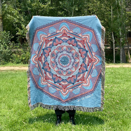 A blue and purple mandala blanket with fringe
