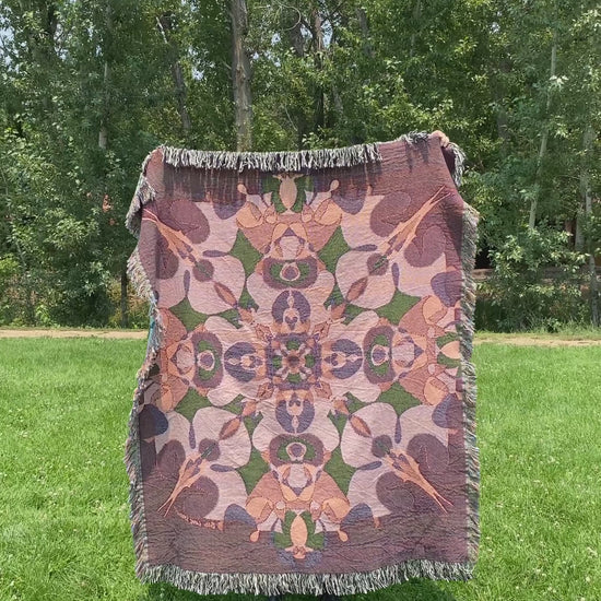 Mackenzie wraps a brightly colored kaleidoscope woven blanket with fringe around her