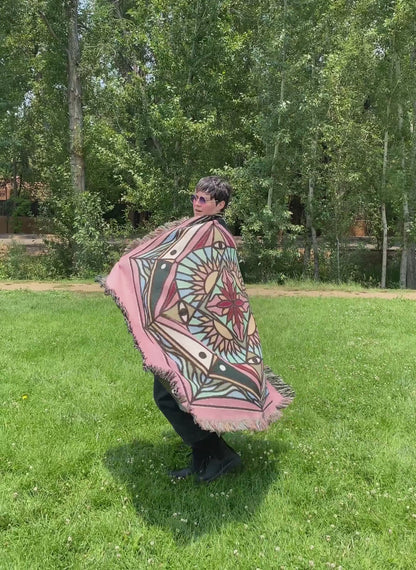 Video of Mackenzie wrapped in a brightly colored mandala woven blanket.
