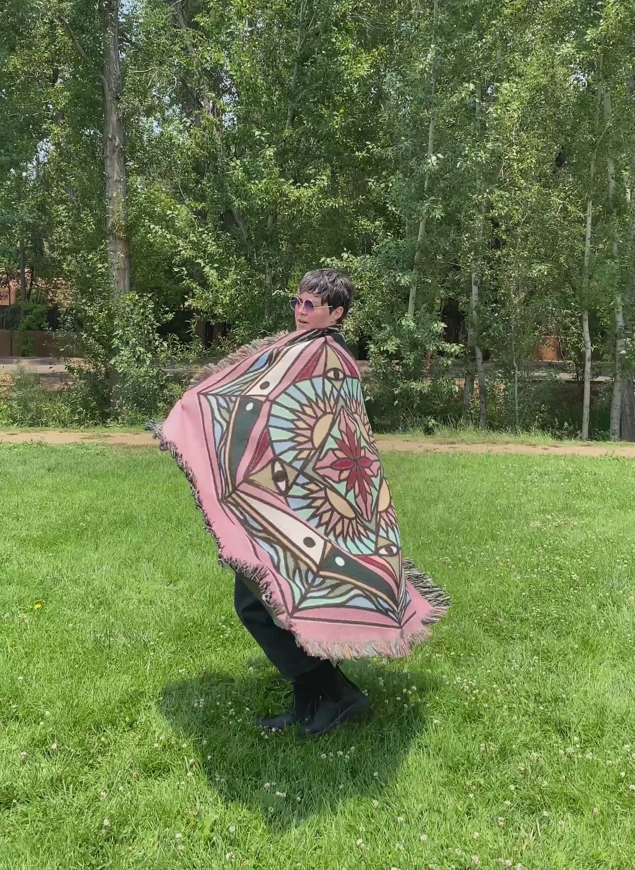 Video of Mackenzie wrapped in a brightly colored mandala woven blanket.