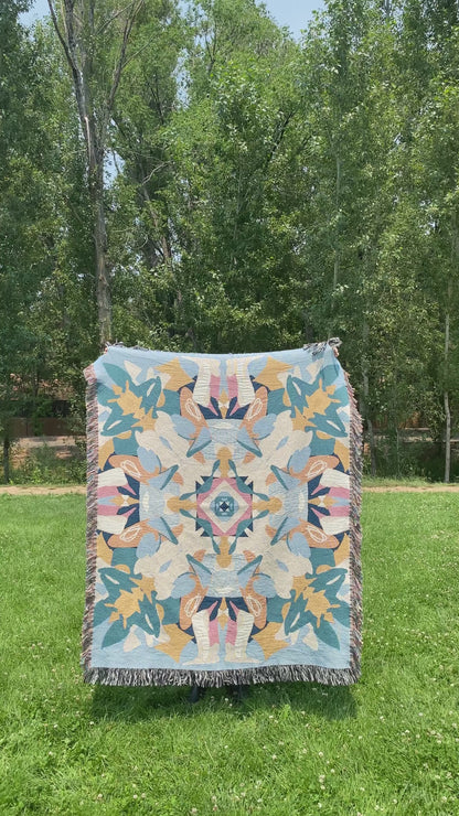 Video of a blue and yellow colorful kaleidoscope patterned woven blanket being turned around.