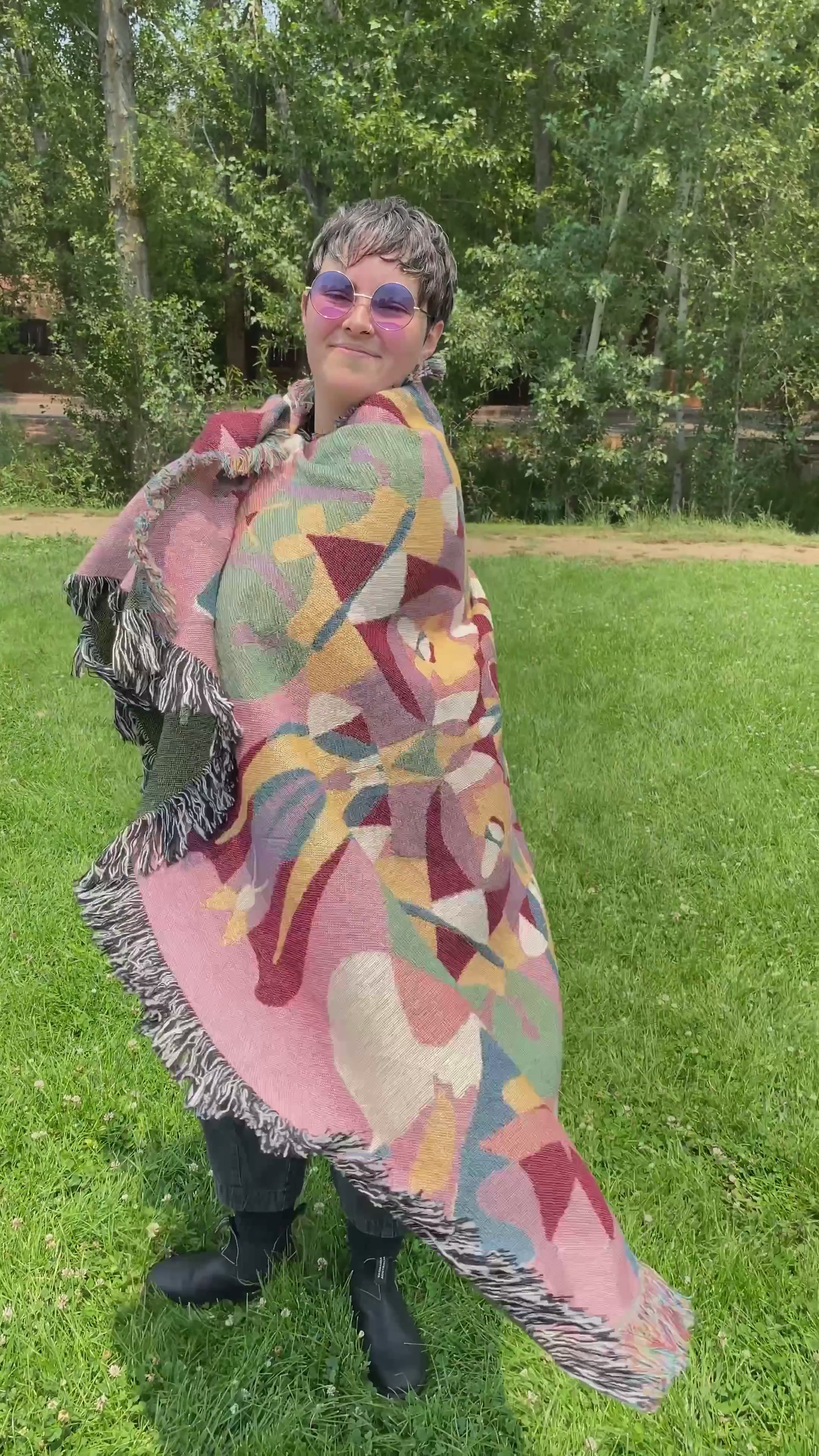 Mackenzie wraps a brightly colored kaleidoscope woven blanket with fringe