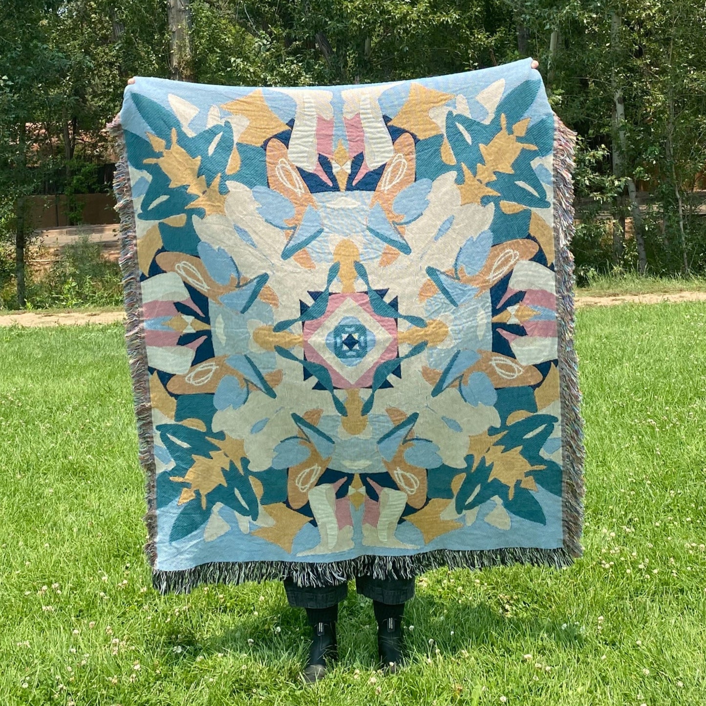 A blue and yellow colorful kaleidoscope patterned woven blanket.