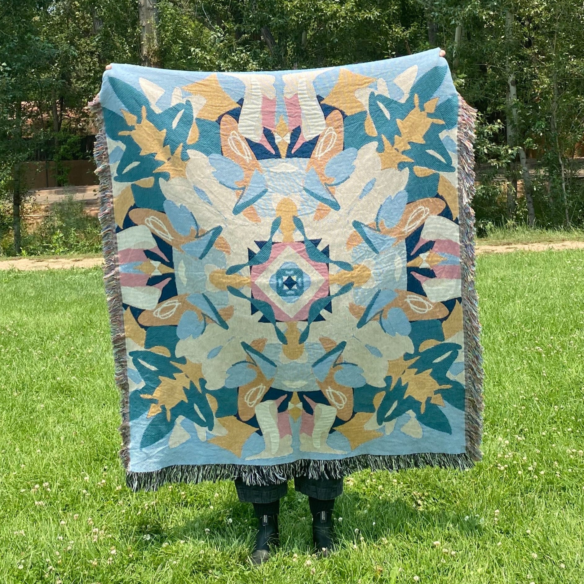 A blue and yellow colorful kaleidoscope patterned woven blanket.