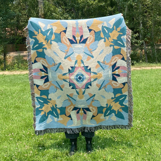 A blue and yellow colorful kaleidoscope patterned woven blanket.